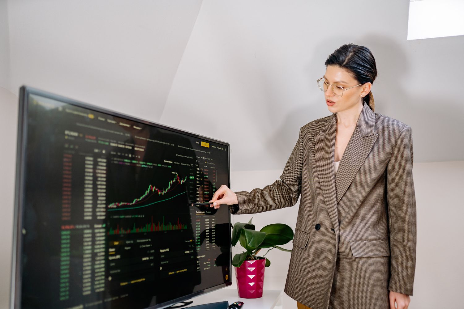 An investor reviewing live market data and price charts on a large screen